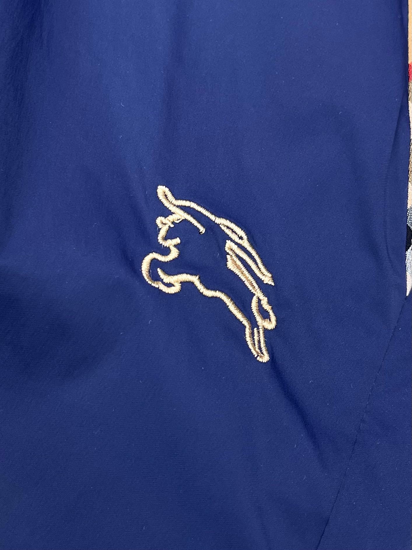 Embroidered Burberry horse logo on blue fabric shorts