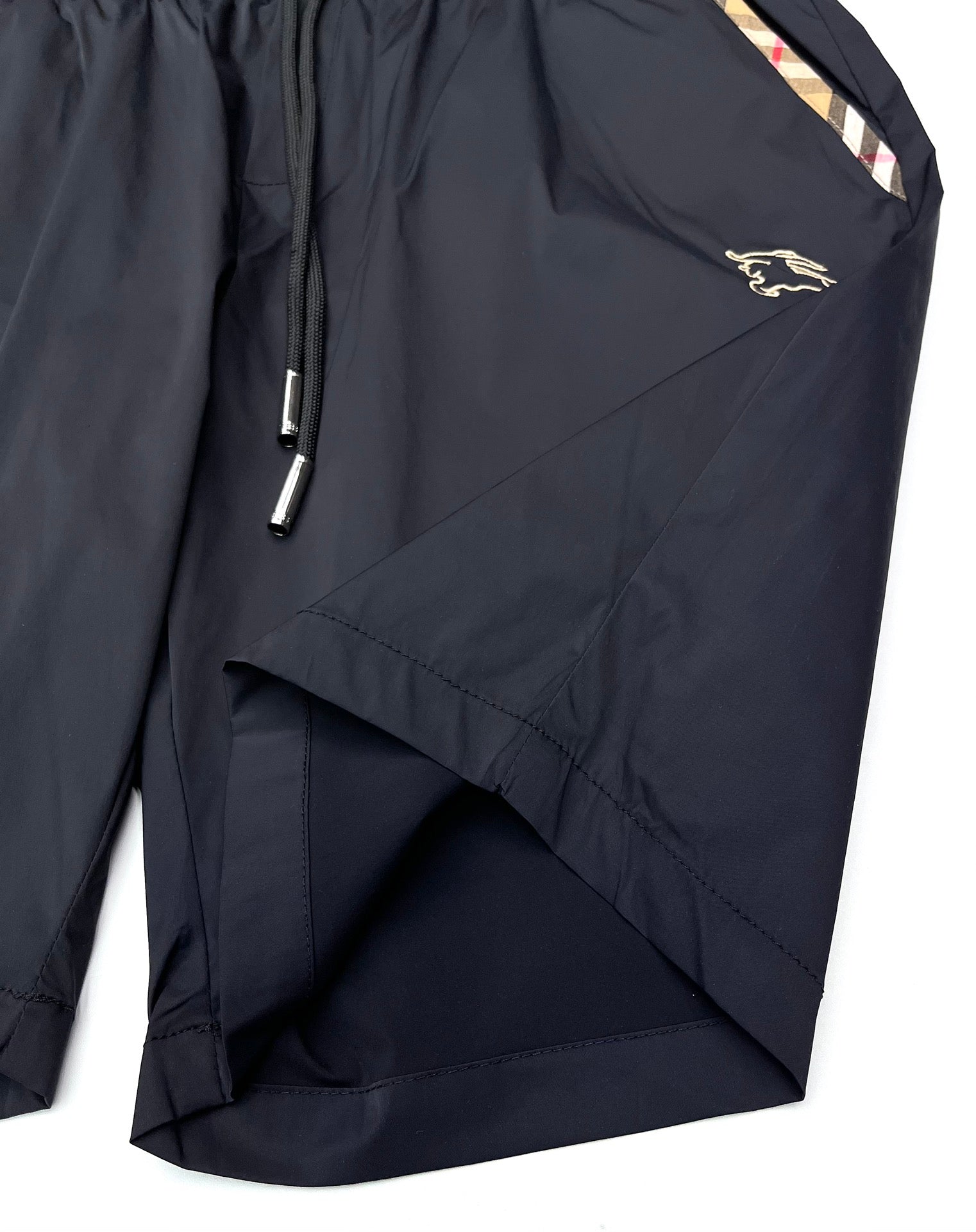 Dark navy Burberry shorts with side pocket and diagonal seam, gold logo