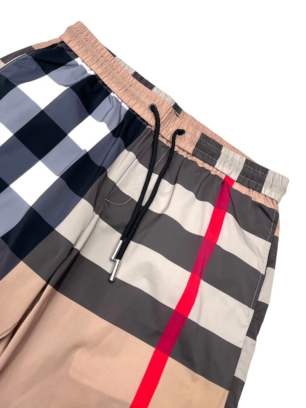 Burberry plaid shorts close-up: elastic waistband, black drawstring, beige/navy check with red line