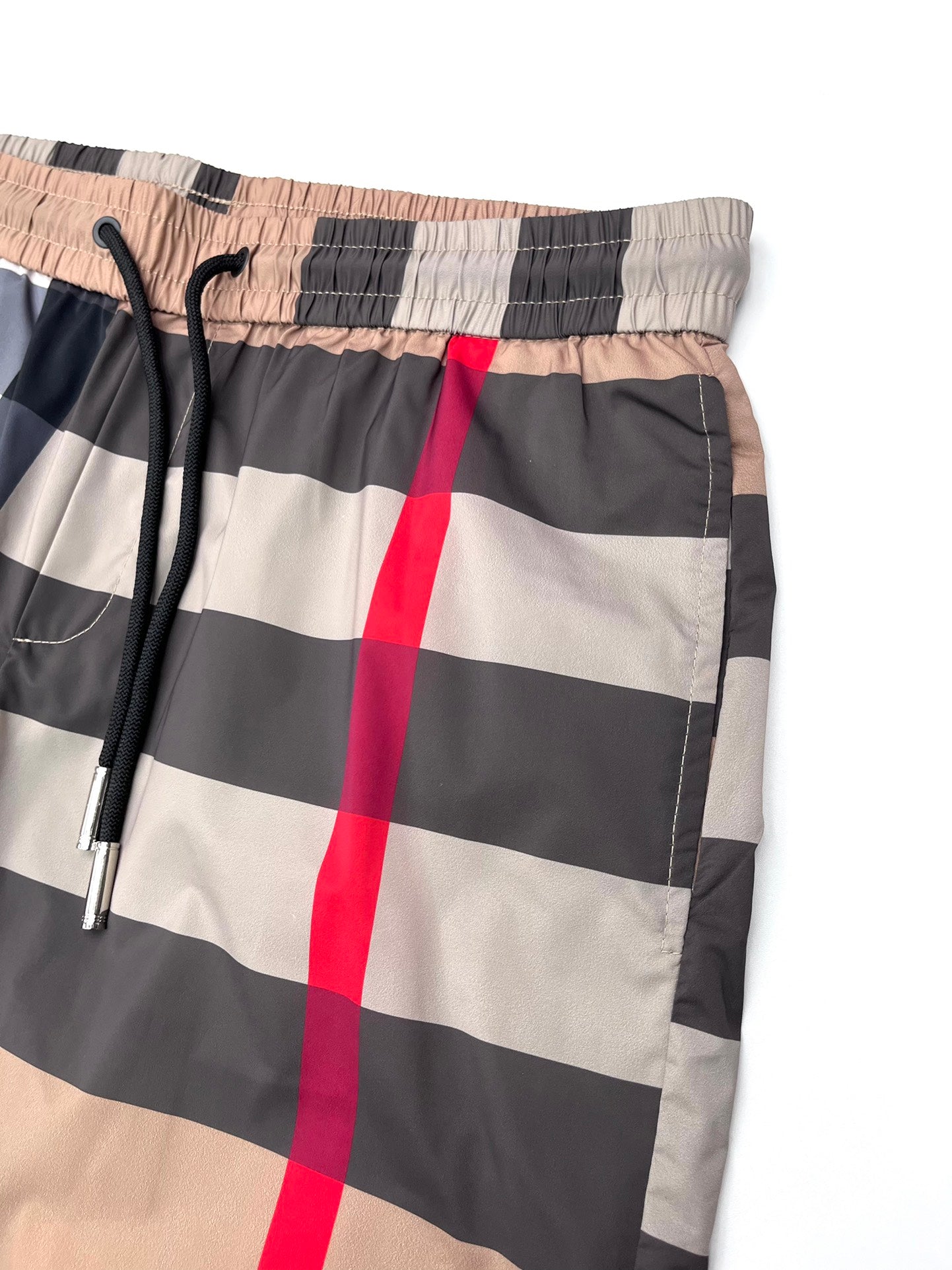 Burberry plaid shorts waistband close-up with elastic back and drawstring, beige/navy checks
