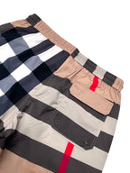 Burberry plaid shorts front pocket area with metal grommets, beige/navy check and red stripe