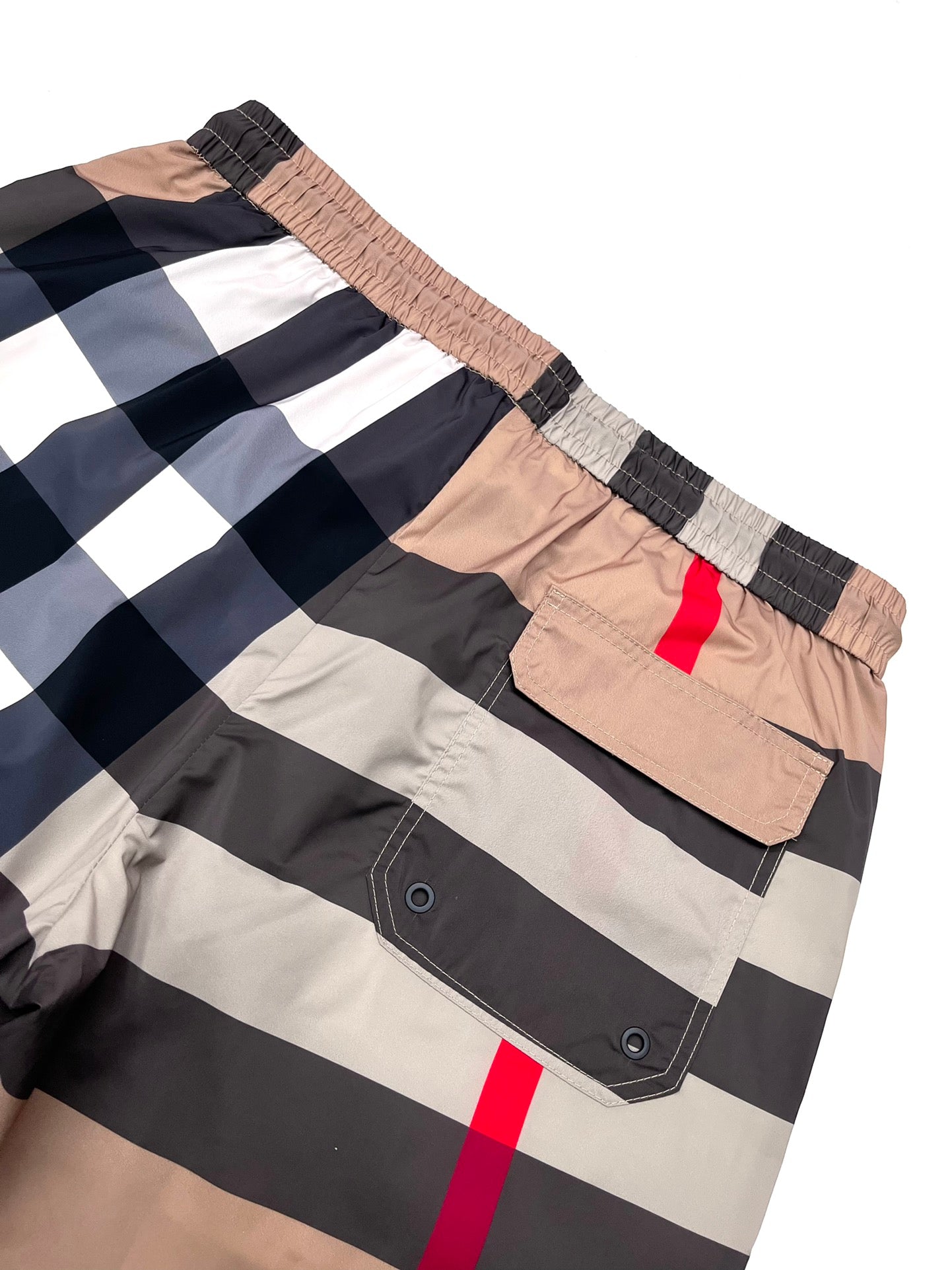 Burberry plaid shorts front pocket area with metal grommets, beige/navy check and red stripe