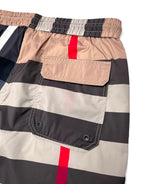 Burberry plaid shorts patch pocket close-up: beige flap pocket, navy checks, red vertical stripe