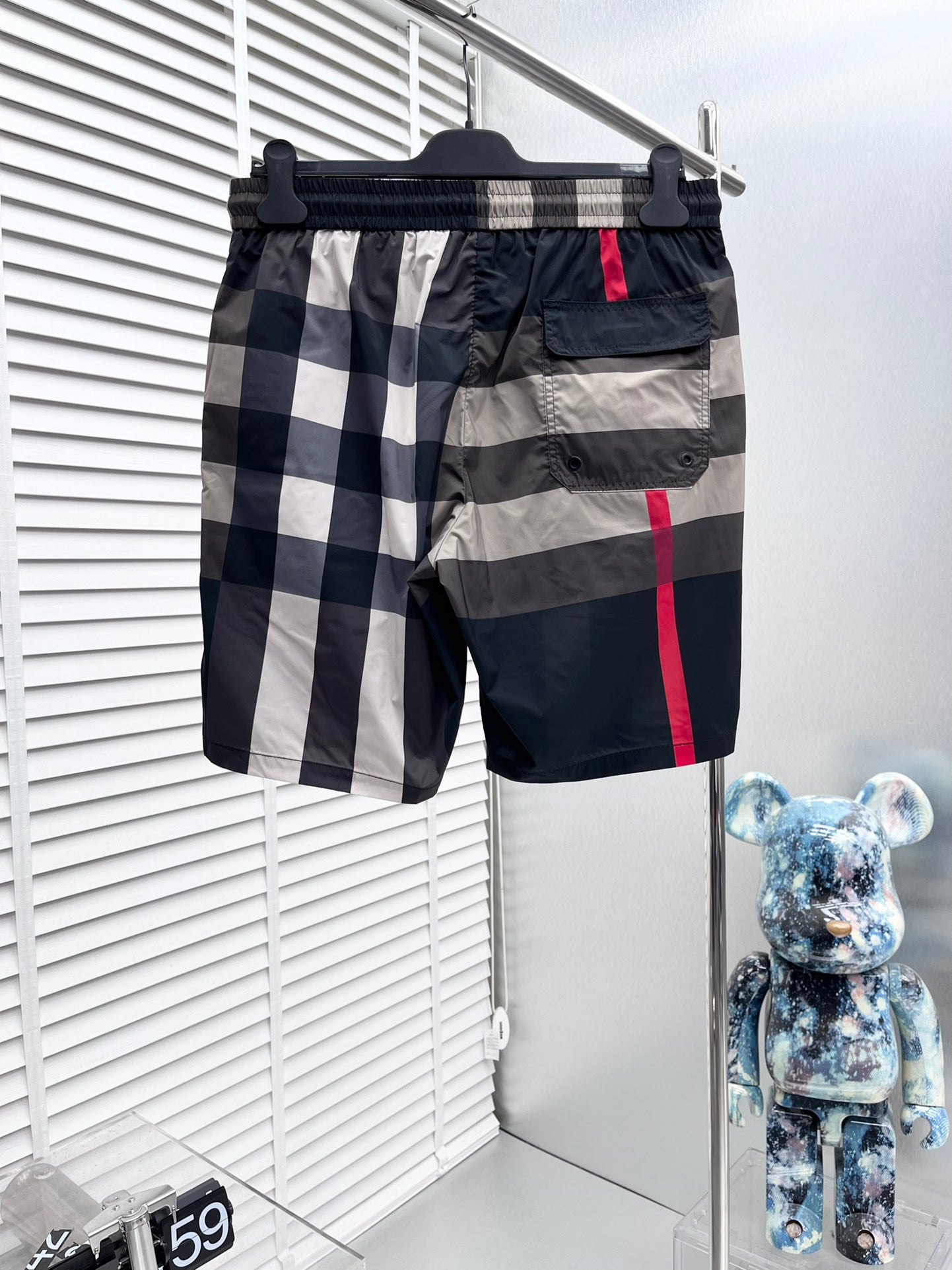 Burberry check shorts front view with elastic waistband, drawstring, red stripe and pocket