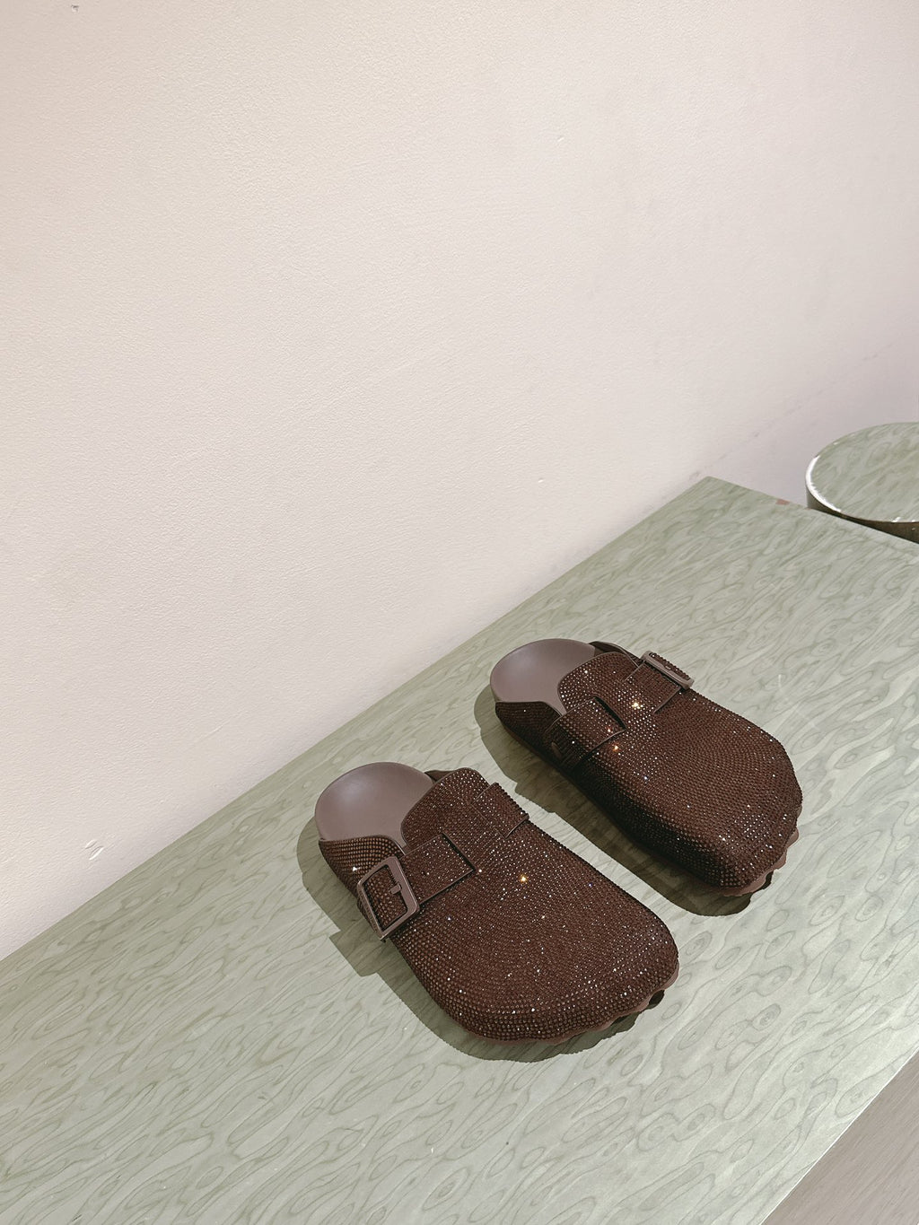 Balenciaga sandals laid flat in dark brown sparkly fabric with buckle strap