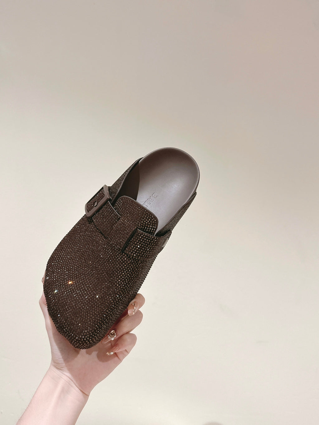 Balenciaga sandals held in hand, dark brown sparkly upper with buckle strap
