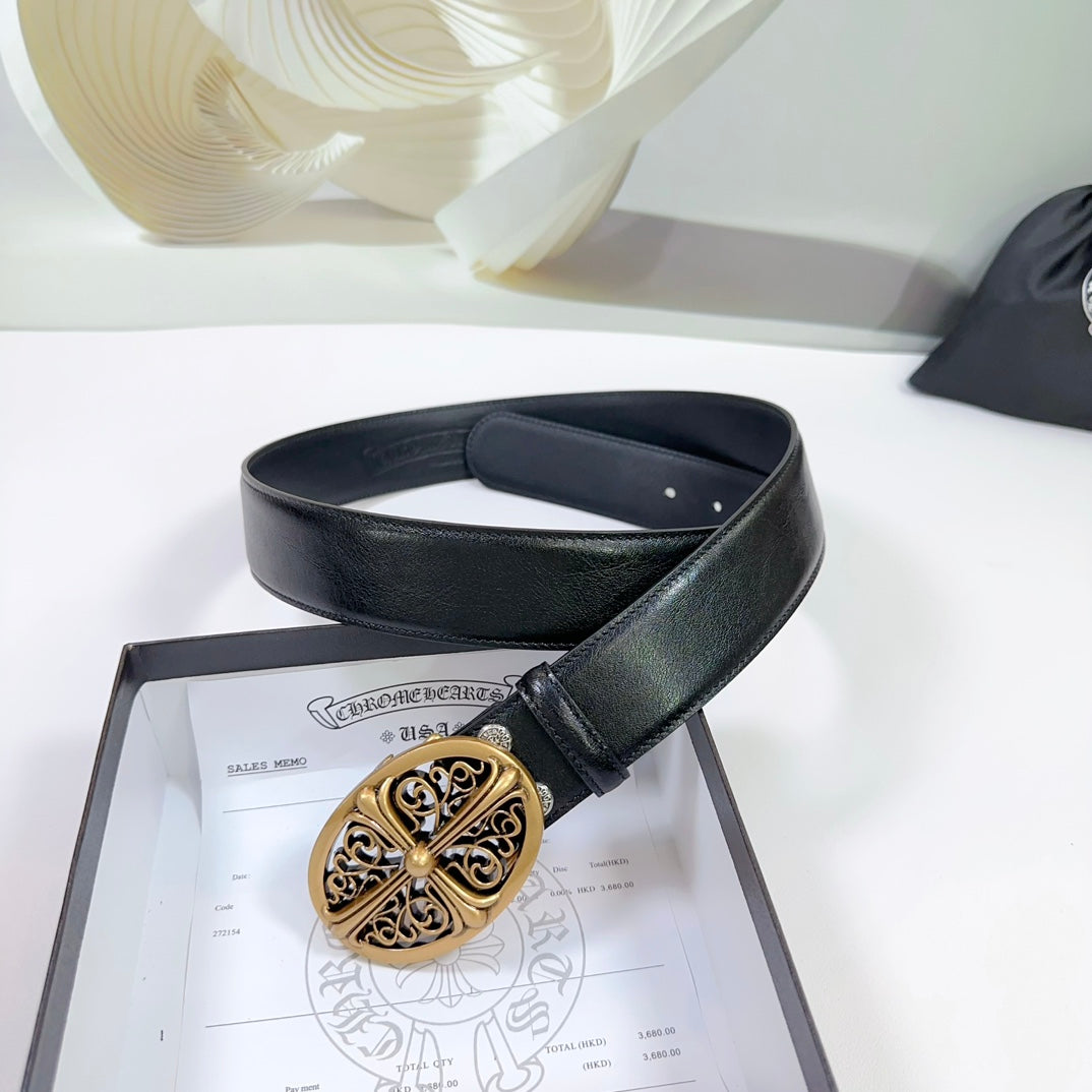 Black leather belt looped over a box, featuring an ornate gold buckle.