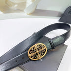 Black leather belt close-up with ornate gold oval buckle and stitched strap edge.
