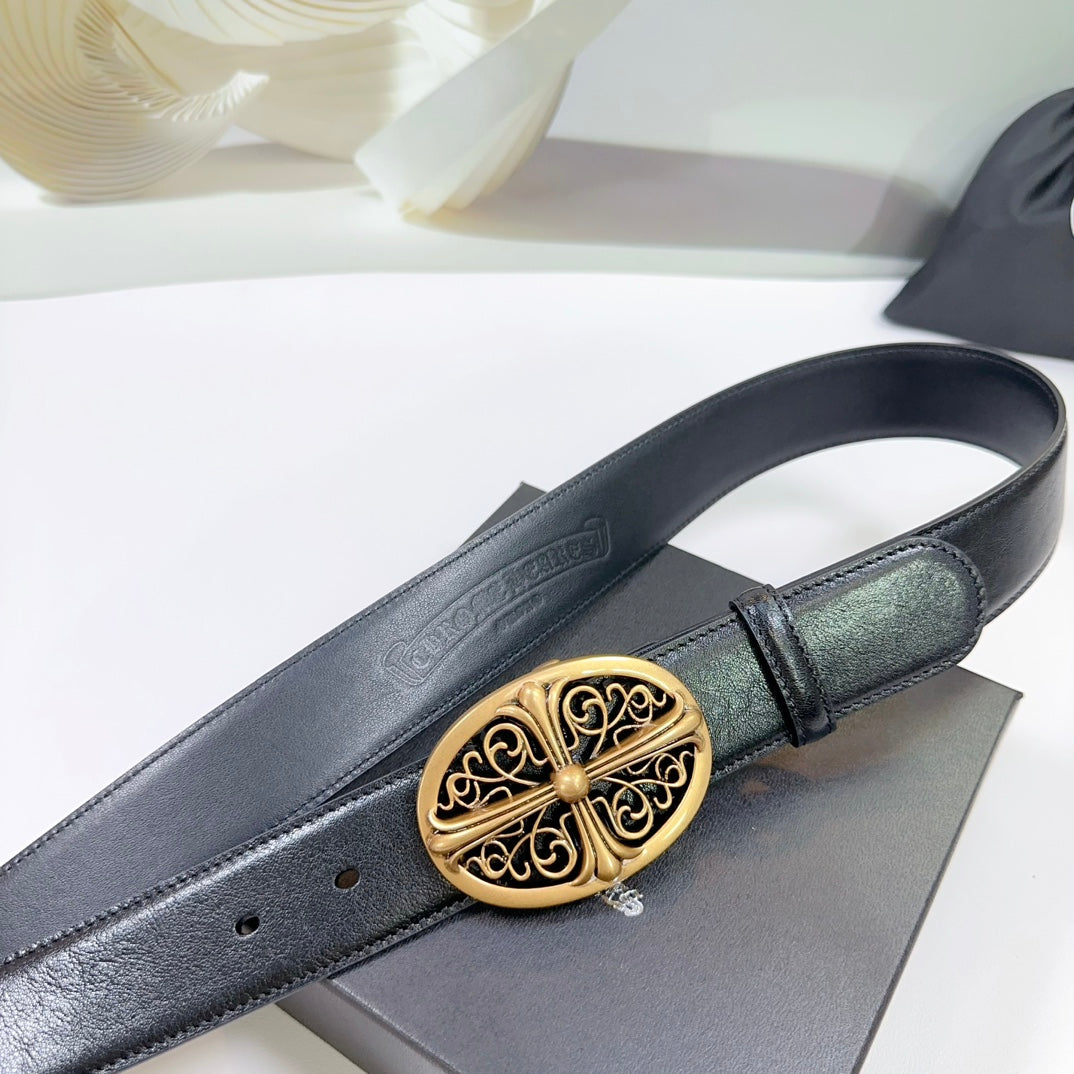 Black leather belt close-up with ornate gold oval buckle and stitched strap edge.