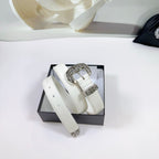 White leather belt laid in box with silver filigree buckle hardware and end ornaments