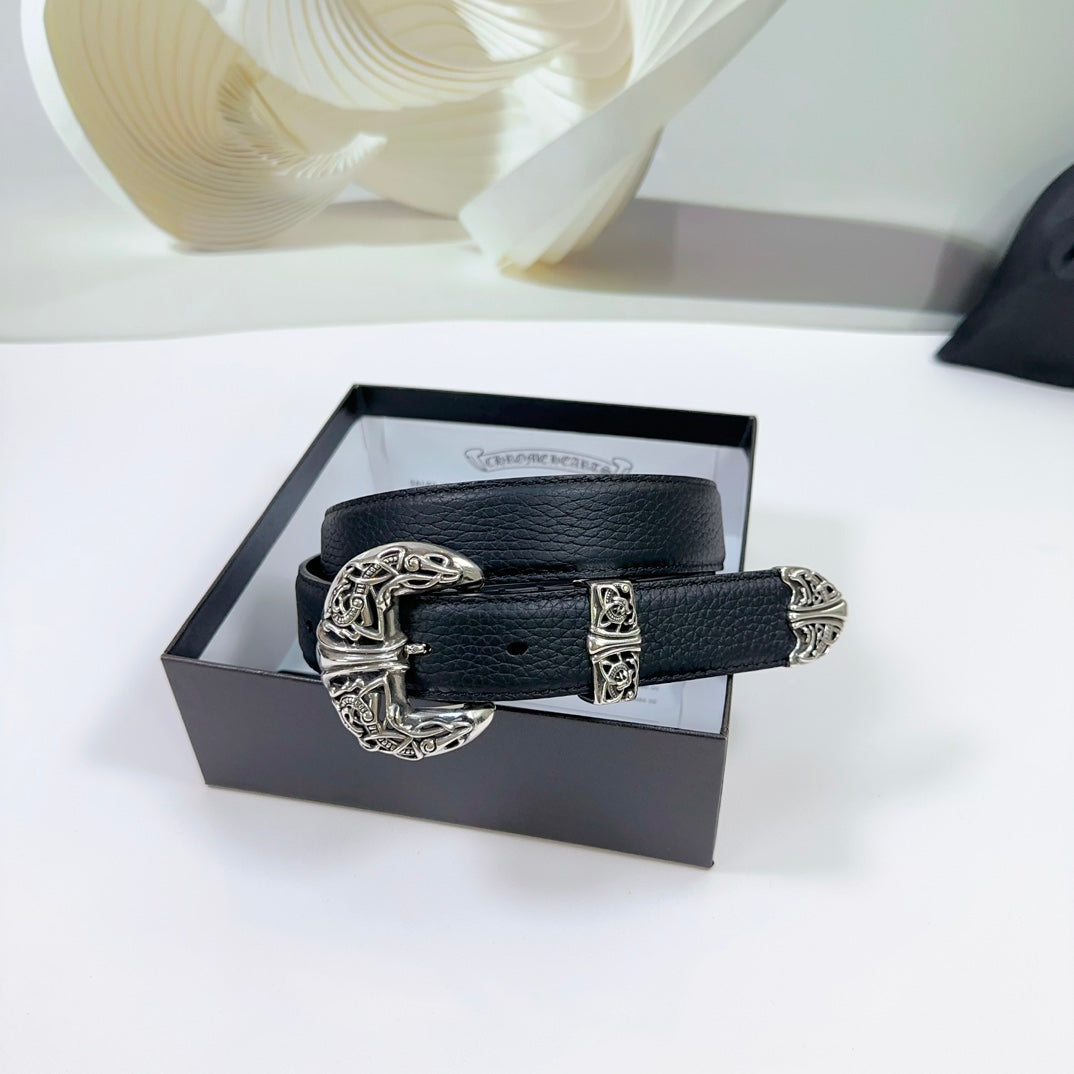 Dark leather belt with ornate silver buckle, resting on a gift box