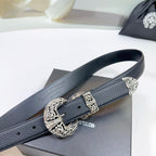 Dark leather belt with ornate silver buckle and keeper, close-up on the strap