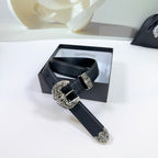 Dark leather belt with ornate silver buckle and decorative plate, on a gift box