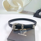 Leather belt with dark strap and ornate silver buckle, shown looped on a box