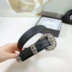 Dark leather belt with ornate silver buckle and rectangular keeper, held in hand