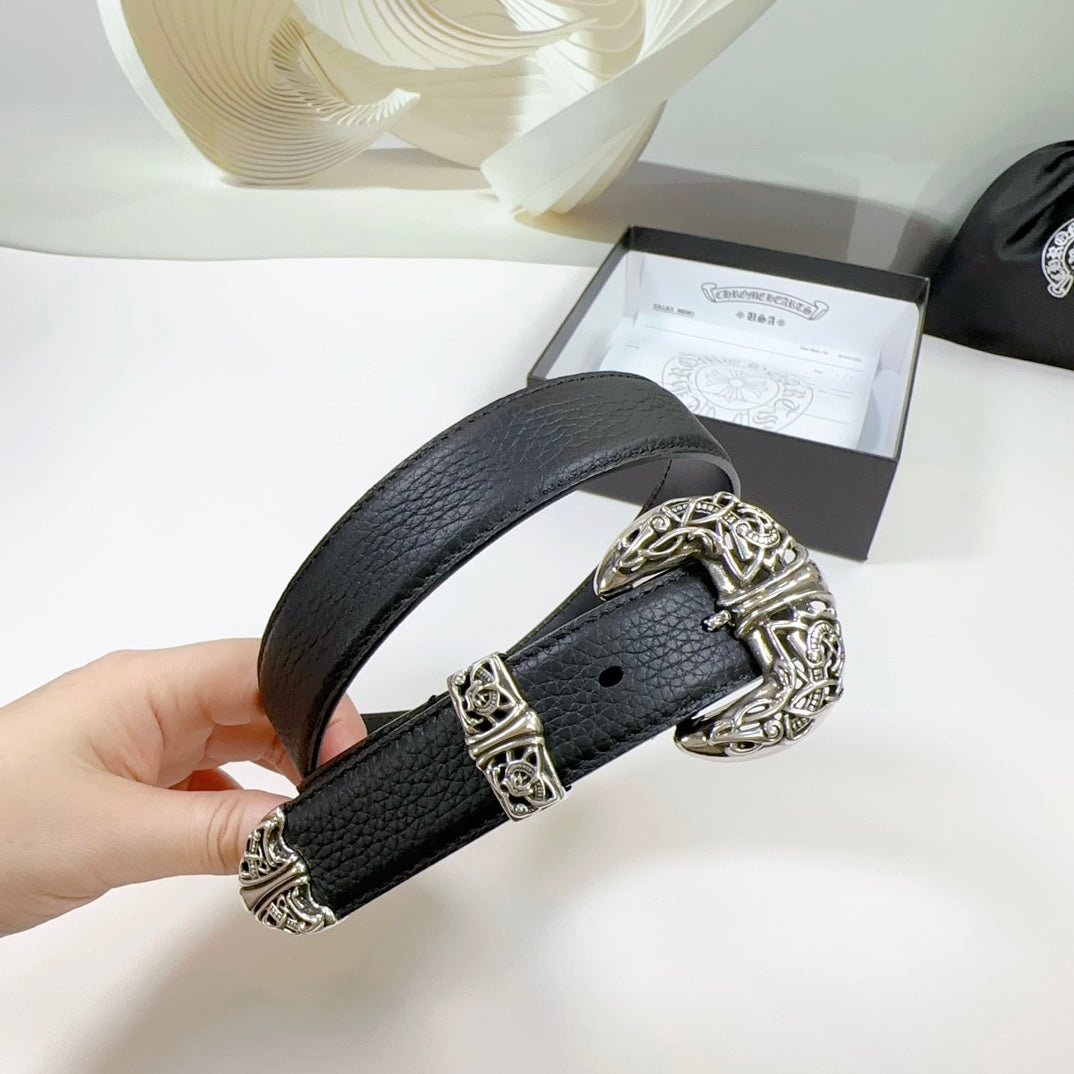 Dark leather belt with ornate silver buckle and rectangular keeper, held in hand