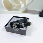 Black leather belt with ornate silver buckle and decorative keeper