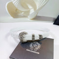 White leather belt with ornate silver buckle and adjustable holes