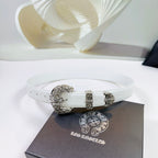 White leather belt with ornate silver buckle and adjustable holes