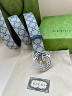 Gucci belt laid out with blue GG patterned strap and silver round interlocking G buckle
