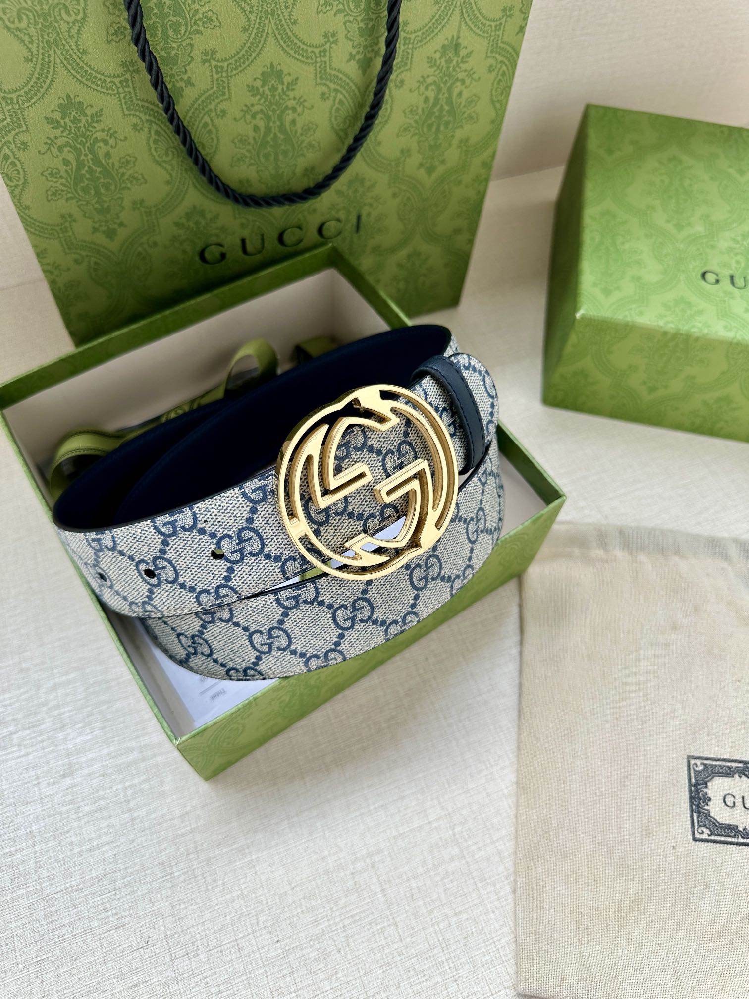 Gucci belt in open box with blue GG canvas strap and gold-tone interlocking G buckle