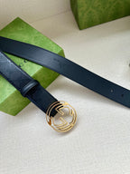 Gucci belt with dark blue strap and gold interlocking G buckle, laid out flat.