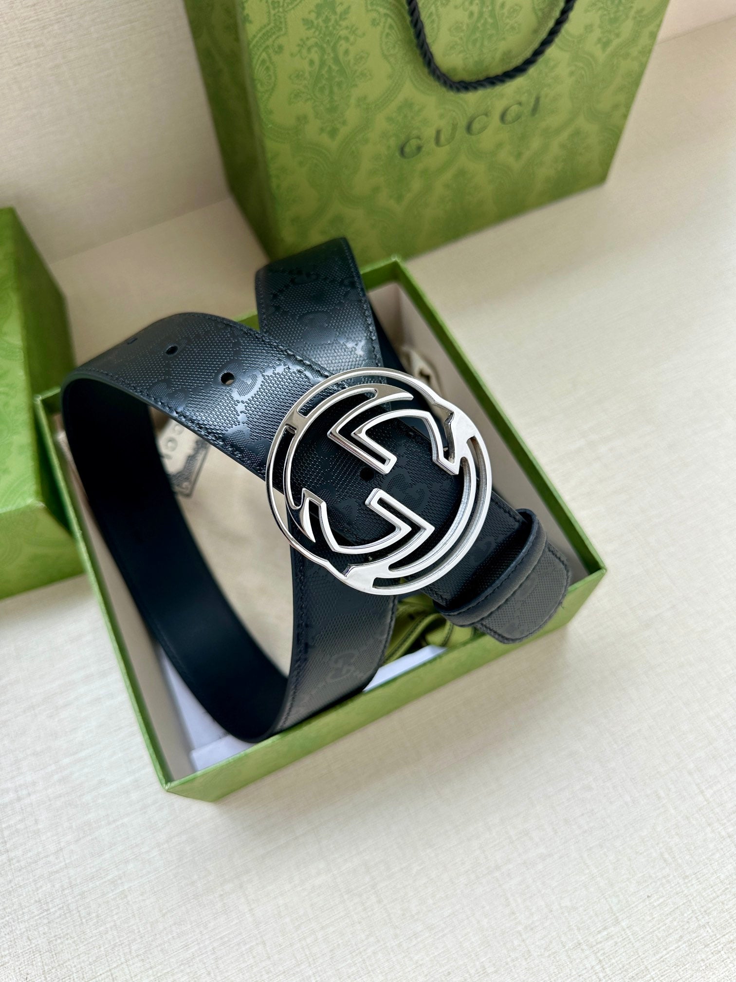 Gucci belt with dark blue strap and silver GG buckle, shown in presentation box.