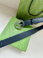 Gucci belt with dark blue strap and silver GG buckle, side close-up.