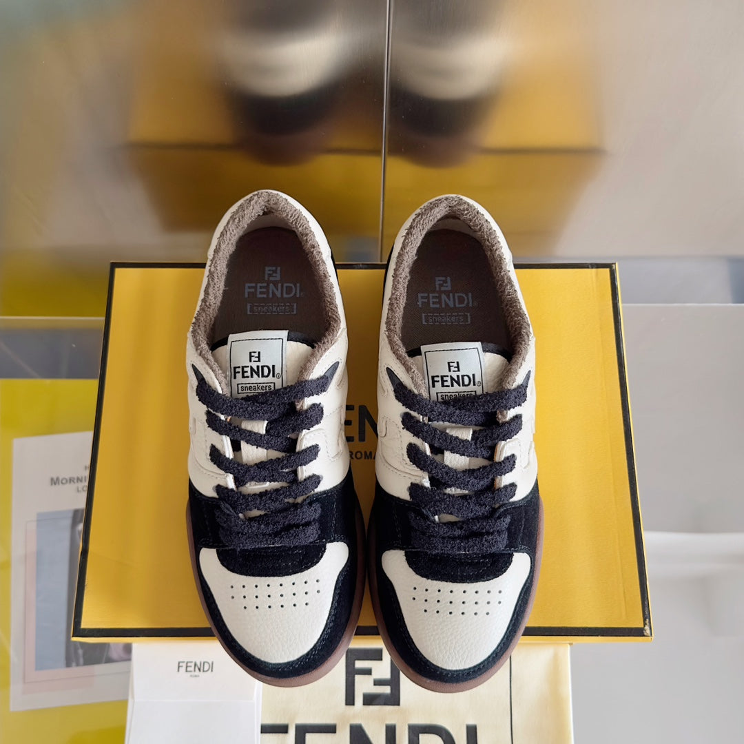 Low-top sneakers front view, white uppers with navy laces and brown rubber outsole