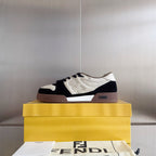 Low-top unisex sneaker on box, white upper with navy panels and brown sole