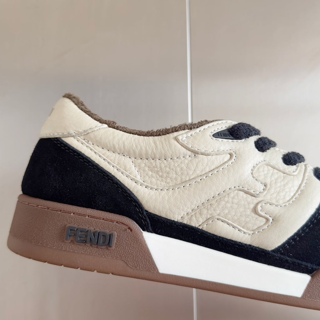 Low-top sneaker close-up, white and navy panels with brown heel and FENDI detail