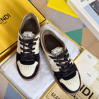 Low-top unisex sneaker with white panels, navy toe and laces, and brown sole