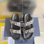 Pair of black Dior slide sandals with Dior Oblique straps and silver buckle closures
