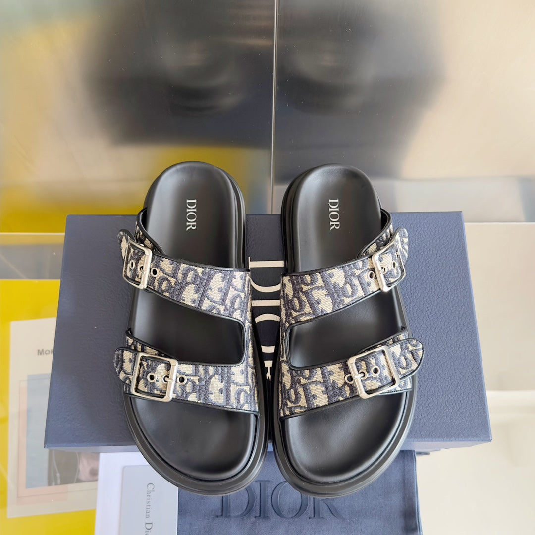 Pair of black Dior slide sandals with Dior Oblique straps and silver buckle closures