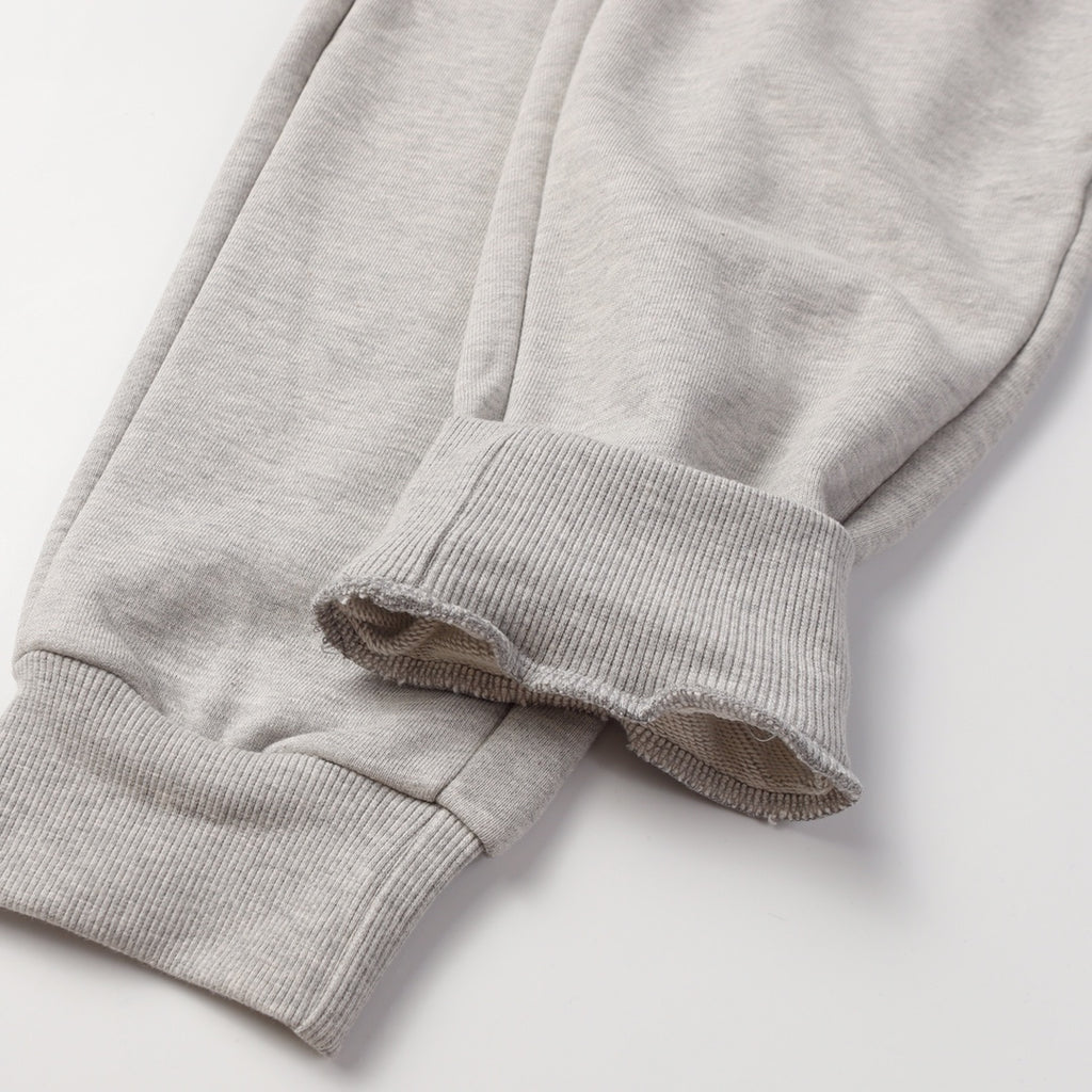 Light gray sweatpants cuffs with ribbed hems and draped leg opening