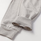 Light gray sweatpants cuffs with ribbed hems and draped leg opening