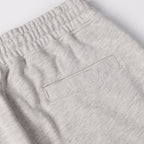 Light gray knit pants with rectangular logo patch