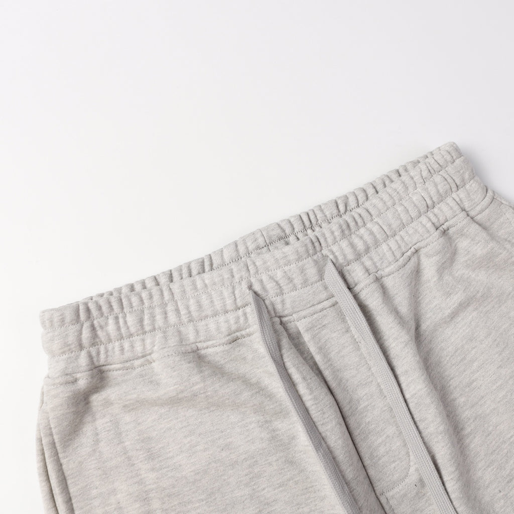 Light gray sweatpants waistband with elastic band and stitched pocket edge