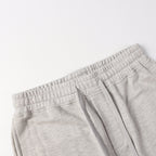 Light gray sweatpants waistband with elastic band and stitched pocket edge