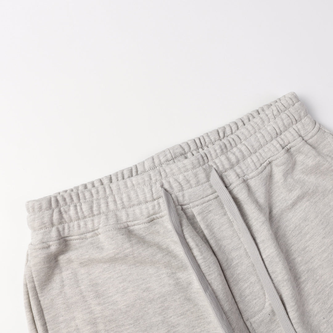 Light gray sweatpants waistband with elastic band and stitched pocket edge