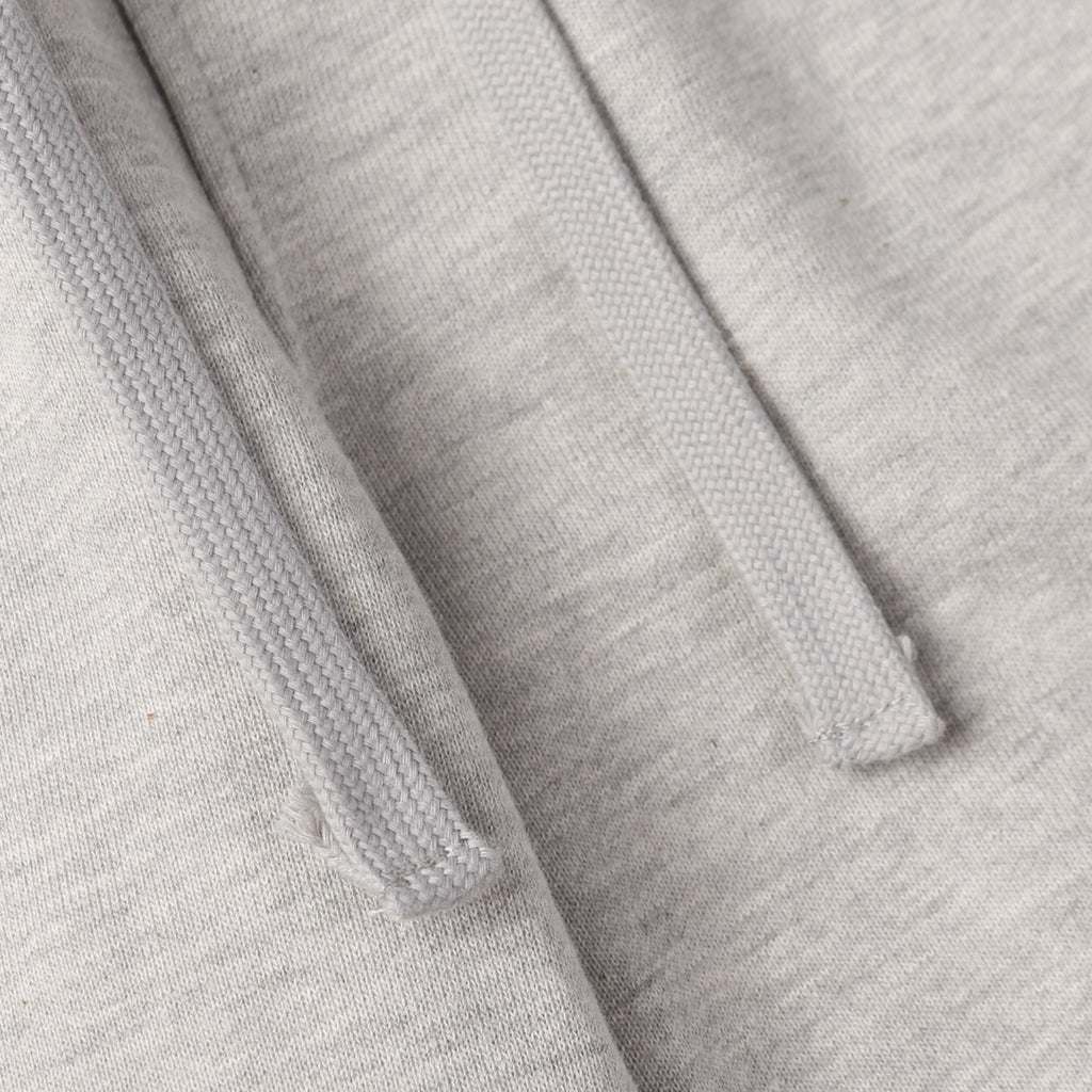 Light gray sweatpants fabric with stitched seams and drawstring channel