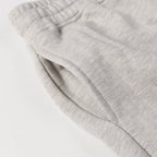 Light gray sweatpants pocket and folded fabric near the waistband