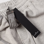 Light gray sweatpants with hang tags and brand label near waistband