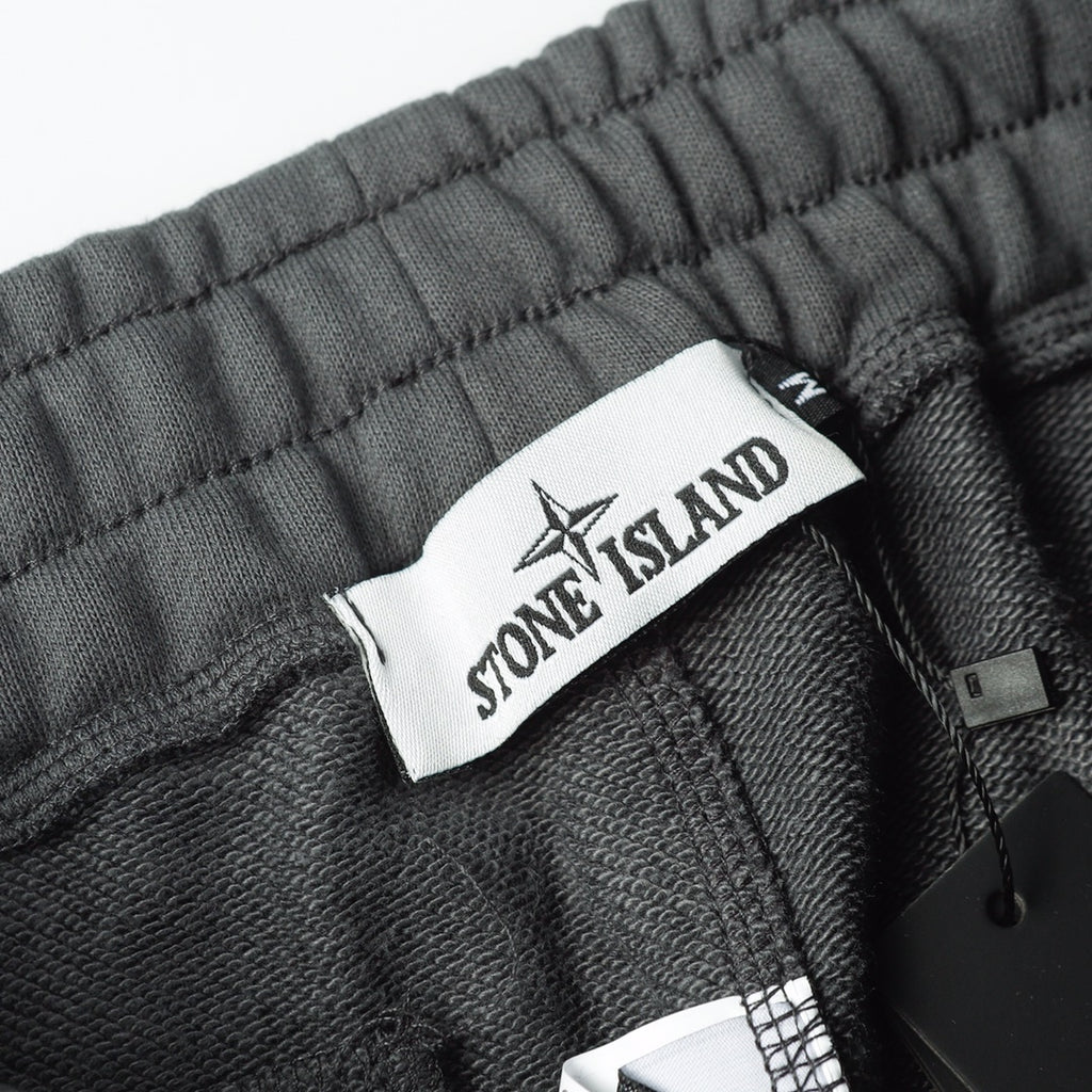 Charcoal gray sweatpants waistband with Stone Island fabric tag and inner drawstring
