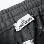 Charcoal gray sweatpants waistband with Stone Island fabric tag and inner drawstring