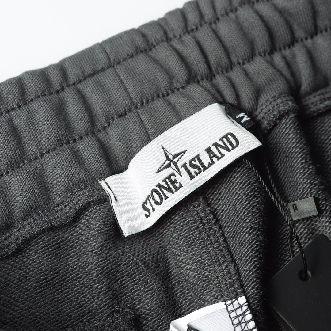 Charcoal gray sweatpants waistband with Stone Island fabric tag and inner drawstring