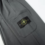 Charcoal gray cargo pocket with Stone Island patch and stitched pocket edge