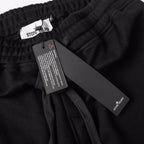 Stone Island black jogger pants with care label and hanging brand tag