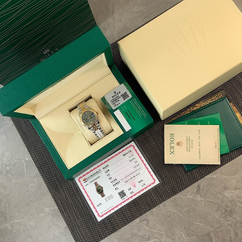 Rolex watch with green dial and included papers, booklet, and certificate cards