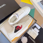 White low-top sneakers with red CC logo and lace-up uppers on shoe box